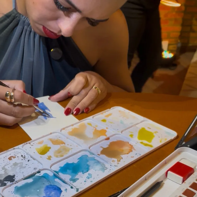 Artista pintando em aquarela durante o evento