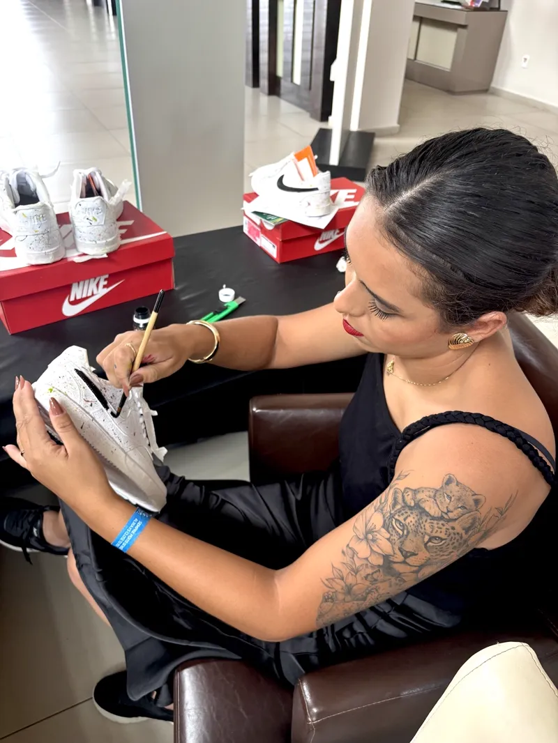 Tênis sendo pintado à mão ao vivo no evento